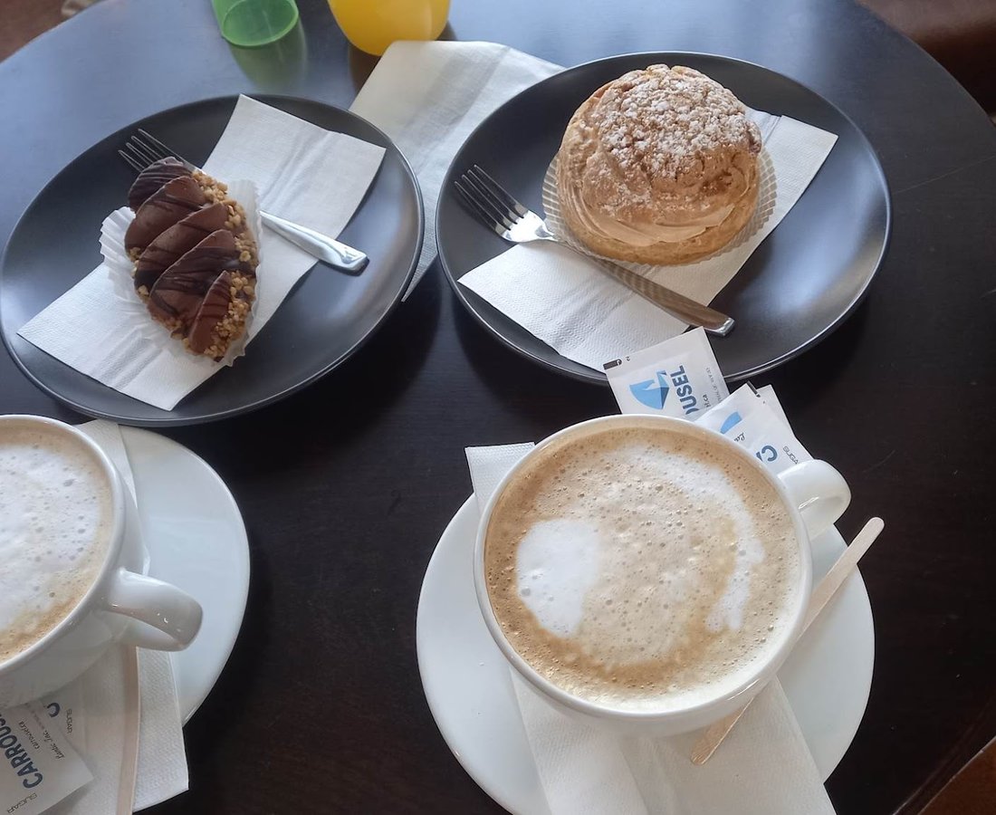 Deux cappuccinos et des pâtisseries, posés sur une table
